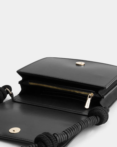 Luxury shoulder and crossbody bag in black, handcrafted from vegan leather and sustainable, cruelty-free Kayla Fabric™—an eco-friendly leather alternative. Designed by a Dutch designer, this authentic bag combines a sleek, rectangular shape with a knotted handle, offering versatility and style for any occasion. Soft gold detailing adds a luxurious touch, making it the best designer handbag for those seeking an ethical, high-quality accessory. Made in Europe.