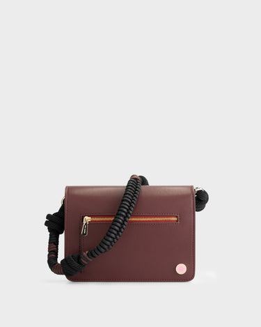 Luxury shoulder and crossbody bag in burgundy, handcrafted from vegan leather and sustainable, cruelty-free Kayla Fabric™—an eco-friendly leather alternative. Designed by a Dutch designer, this authentic bag combines a sleek, rectangular shape with a knotted handle, offering versatility and style for any occasion. Soft gold detailing adds a luxurious touch, making it the best designer handbag for those seeking an ethical, high-quality accessory. Made in Europe.