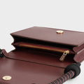 Luxury shoulder and crossbody bag in burgundy, handcrafted from vegan leather and sustainable, cruelty-free Kayla Fabric™—an eco-friendly leather alternative. Designed by a Dutch designer, this authentic bag combines a sleek, rectangular shape with a knotted handle, offering versatility and style for any occasion. Soft gold detailing adds a luxurious touch, making it the best designer handbag for those seeking an ethical, high-quality accessory. Made in Europe.