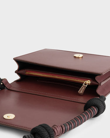 Luxury shoulder and crossbody bag in burgundy, handcrafted from vegan leather and sustainable, cruelty-free Kayla Fabric™—an eco-friendly leather alternative. Designed by a Dutch designer, this authentic bag combines a sleek, rectangular shape with a knotted handle, offering versatility and style for any occasion. Soft gold detailing adds a luxurious touch, making it the best designer handbag for those seeking an ethical, high-quality accessory. Made in Europe.