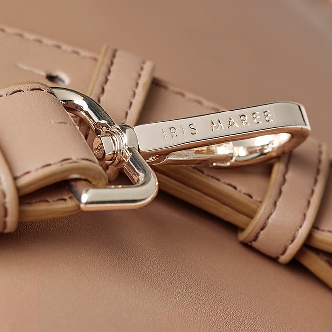  Close up shot of golden strap clip with engraved Iris Maree logo