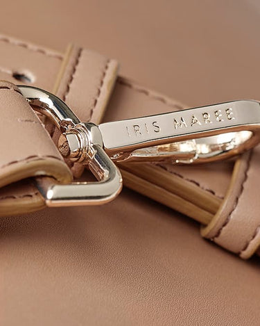  Close up shot of golden strap clip with engraved Iris Maree logo