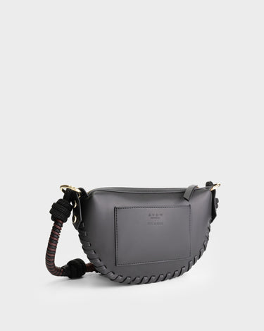 Luxury mini shoulder bag in black, handcrafted in collaboration with AVDW Antwerp from vegan, sustainable, and cruelty-free Kayla Fabric™—an eco-friendly leather alternative. Designed by a Dutch designer, this authentic bag features a compact, curved design with hand-knotted cords and soft gold accents, blending artistry with practicality. The best designer handbag for those seeking ethical elegance. Made in Europe.