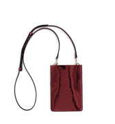 Merry Pouch Ruby Red Metallic phone case bag with long cross-body strap and gold accessory clips on bag with gold Iris Maree logo on the front of the bag made from environmentally conscious material Kayla Fabric