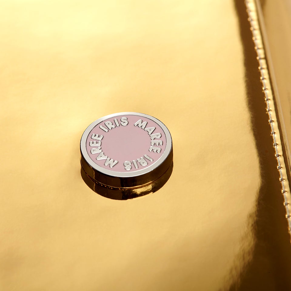 Julian Petit Golden Light Metallic close up shot of the Iris Maree pink and white logo on bag